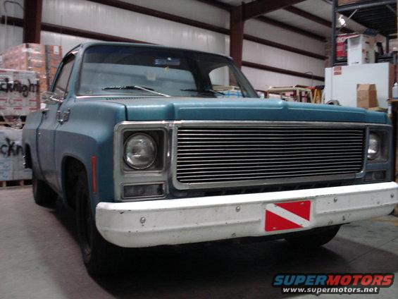 1979 Chevrolet C/K Pickup front view, blue body, chrome grille, white bumper with dive flag sticker