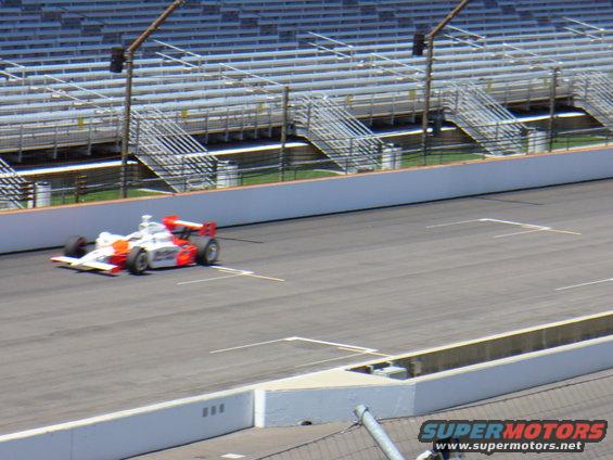 IndyCar on race track with grandstands in background