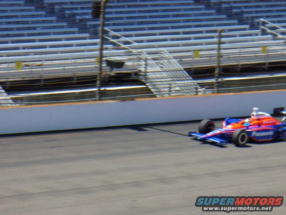 Blue and orange IndyCar with Panasonic logo on track