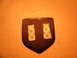 1996 Ford Probe - A dark emblem with adhesive strips is shown against an orange textured background.