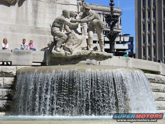 Monument with fountain and people sitting on the edge