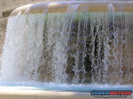 Waterfall cascading over stone structure with SuperMotors logo