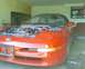 1993 Ford Probe - The front of a red 1993 Ford Probe is visible with its hood open, revealing the engine compartment.
