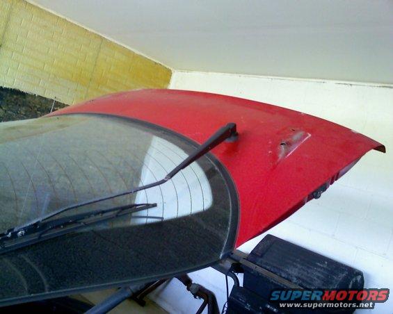Red car trunk lid and rear window with wiper assembly. Supermotors.net logo visible