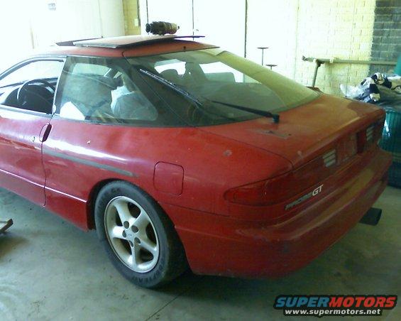 Red 1993 Ford Probe GT parked in garage, rear quarter view