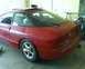 1993 Ford Probe - The rear of a red 1993 Ford Probe GT is visible, parked indoors with a sunroof and a roof-mounted accessory.