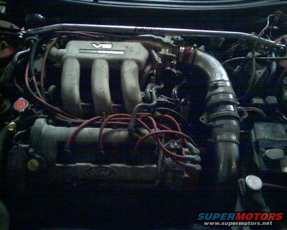 1993 Ford Probe engine bay with V6 engine, red spark plug wires, and silver intake piping