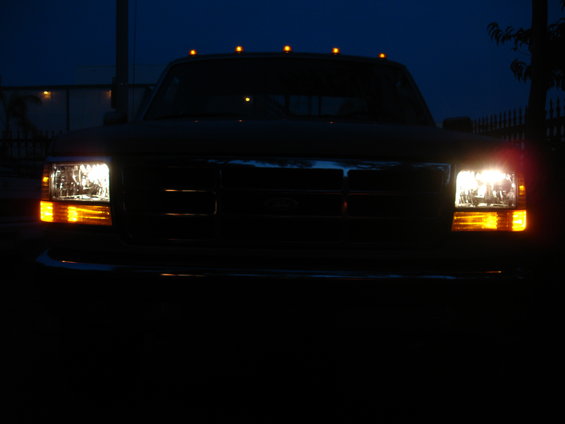 Front view of a 1992 Ford F-350 with headlights and marker lights on at dusk