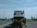 2007 Ford Mustang - White convertible car being transported on a car carrier, seen from the rear.