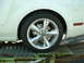 2007 Ford Mustang - A close-up view of a chrome wheel and fender of a white vehicle, possibly a Ford Mustang, on a trailer.