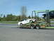 2007 Ford Mustang - A white 2007 Ford Mustang convertible is loaded onto a car carrier, with a black truck visible on the upper deck.