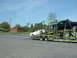 2007 Ford Mustang - A car carrier transports a white 2007 Ford Mustang and a black pickup truck.