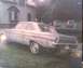 1901 Honda Odyssey - A vintage sedan sits in front of a house, showing its age.