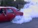 1901 Honda Odyssey - A red car performs a burnout, creating a large cloud of smoke.