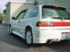 1901 Honda Odyssey - A white hatchback with a sporty body kit is parked outside a building.