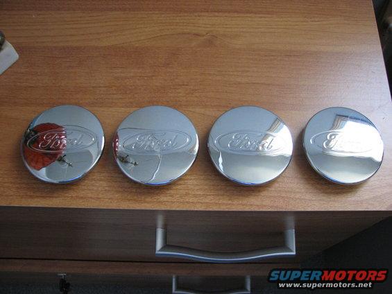 Four chrome Ford hubcaps with the Ford logo embossed