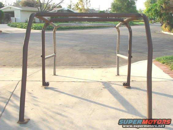 Roll cage frame on concrete driveway, houses in background