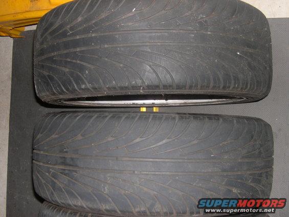Two tires and rims stacked, one on top of the other