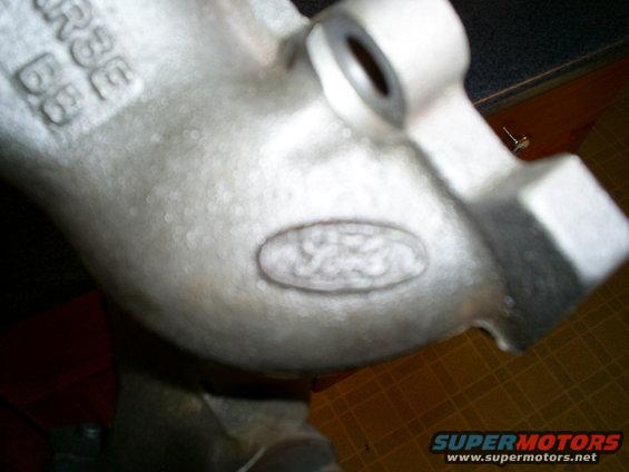 Close-up of a metal casting showing an oval Ford logo and cast-in numbers