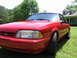 1967 Ford Mustang - A red Ford Mustang GT is parked on a grassy lawn in front of a house.