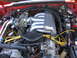1967 Ford Mustang - Close-up view of a vehicle's engine bay, highlighting a chrome intake manifold and bright yellow spark plug wires.