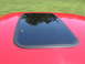 1967 Ford Mustang - Close-up of a car's sunroof with a reflection of trees in the glass.