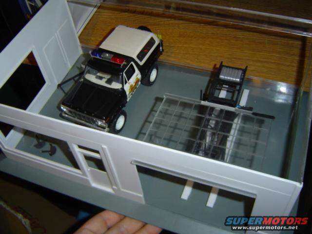Model police SUV with light bar inside a diorama garage