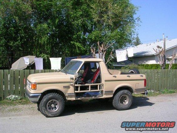 Tan 1987 Ford Bronco 4x4 with doors removed, side view