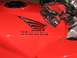 2002 Honda Interceptor - A close-up view of a red motorcycle's fuel tank, the Honda wing logo and a pair of red racing gloves resting on its surface.