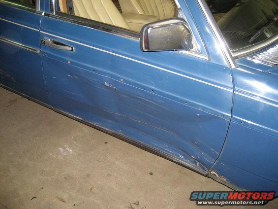 1982 Mercedes-Benz D-Class side door with significant dents and rust near the bottom