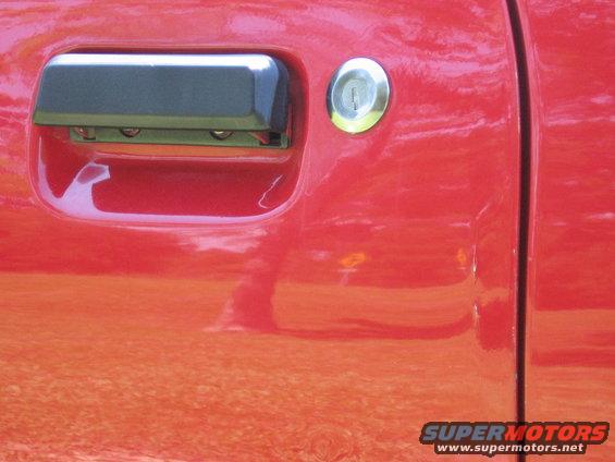 Close-up of a red car door handle and keyhole