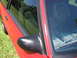 1967 Ford Mustang - Close-up view of a red car's side door, mirror, and interior.