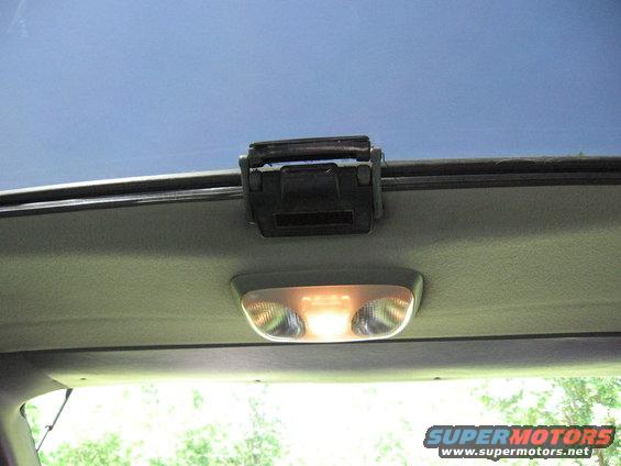 Interior overhead light fixture with a black clip above it