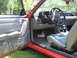 1967 Ford Mustang - The interior of a red car is shown, a manual transmission and aftermarket pedals.