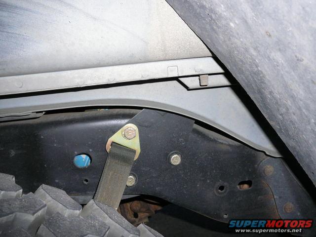 close-up of vehicle frame, tire, and strap