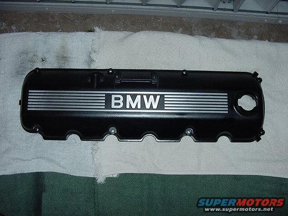 Black BMW valve cover with silver stripes and BMW logo