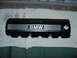1989 BMW 3 Series - A black BMW valve cover with silver stripes and the BMW logo is shown, likely a replacement part.