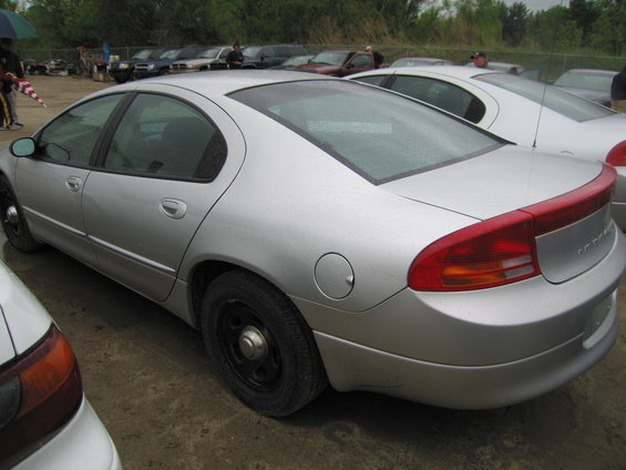 Silver sedan parked outdoors, rear quarter view. Another silver car is to the right