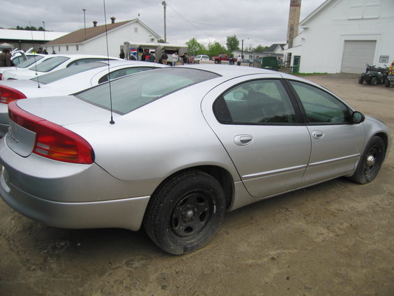 Silver sedan side view, parked outdoors with other vehicles