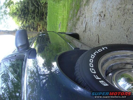 Side view of a dark sedan with BFGoodrich tires and chrome wheels