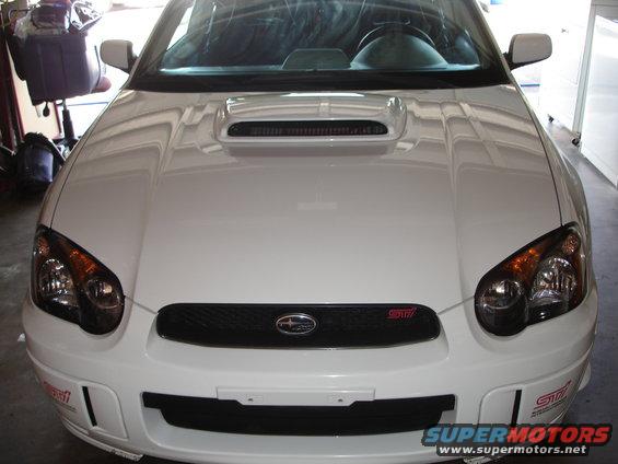White Subaru Impreza WRX STI, front view. Hood scoop and STI badge visible