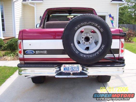 Rear view of a red and white Ford Bronco with a spare tire mounted on the back. License plate reads WNA-9219
