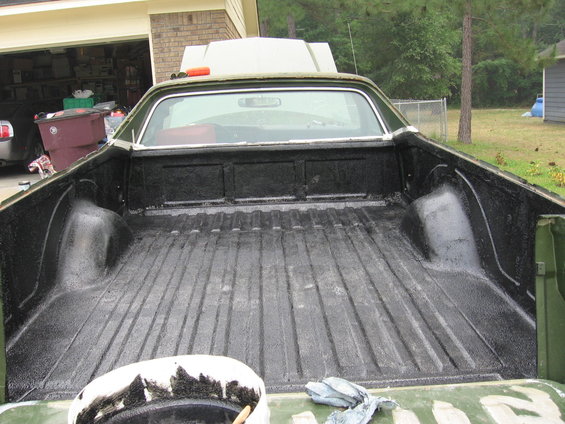 Truck bed with black spray-on liner, hood open