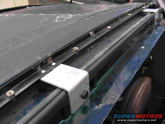 Here is the center cab mount fabricated from 3" wide aluminum. Key is making the bracket just a little bit long front to back so that it pushes against the cab when bolted in, which helps keep the cab mount channel sturdy when snapping or unsnapping the top.