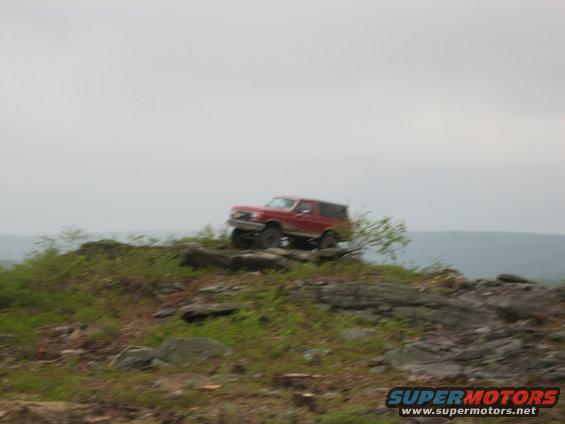 red SUV climbing rocky hill