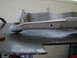 1996 Ford Bronco - A gray suspension component, possibly a control arm, is shown with a metal shim inserted.