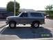 1996 Ford Bronco - A two-tone gray 1996 Ford Bronco is parked in a lot with other vehicles visible.