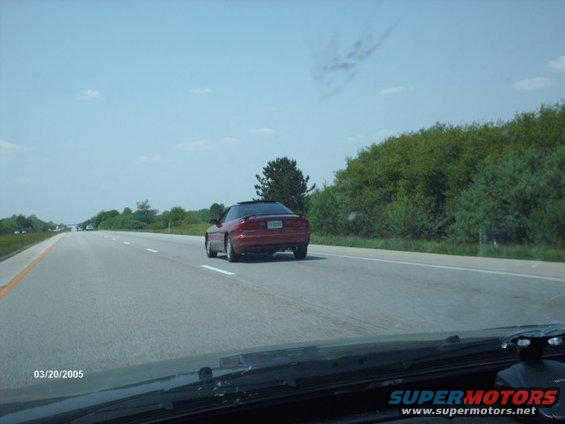 Red 1995 Ford Probe driving on highway, seen from another car