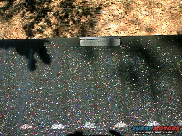 Sparkling black paint on a vehicle part with a chrome strip