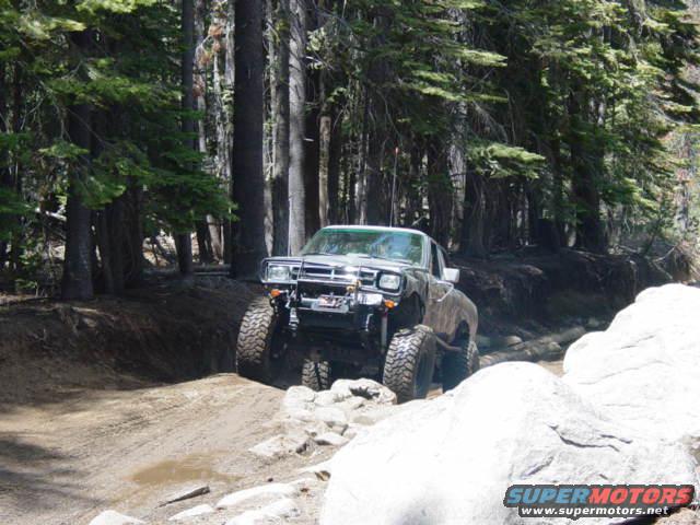 Modified pickup truck with large tires on a rocky trail